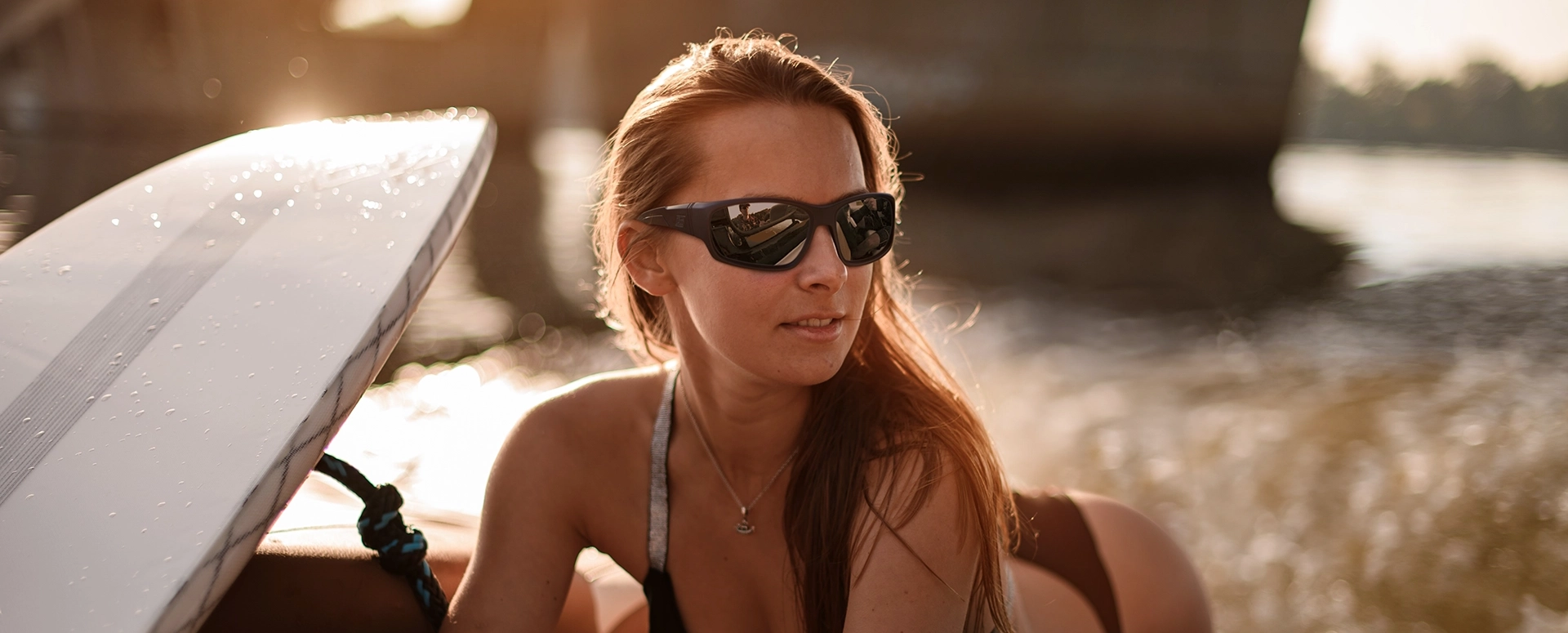 Lady with surfboard wearing sunglasses