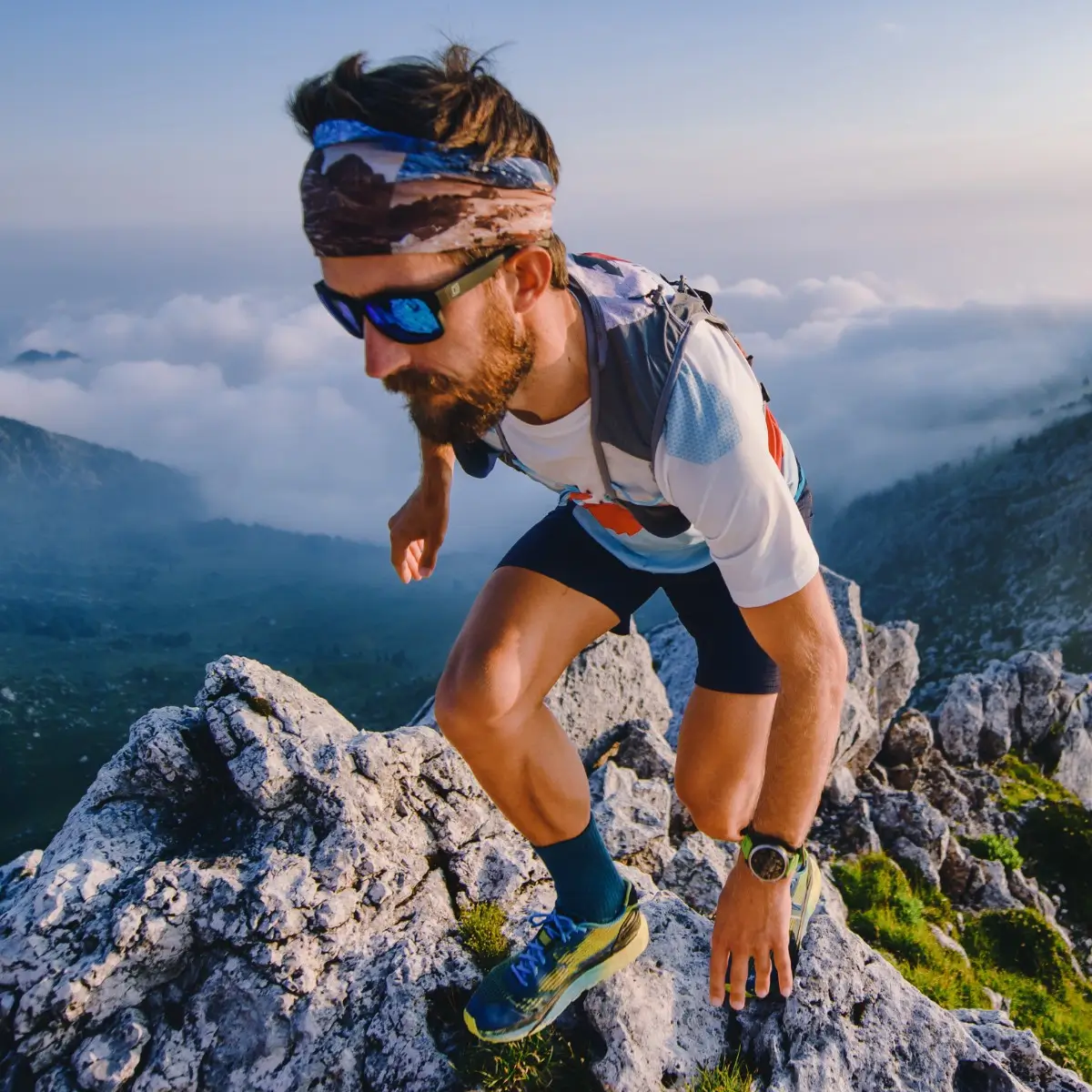 Man climbing mountain with sunglasses on